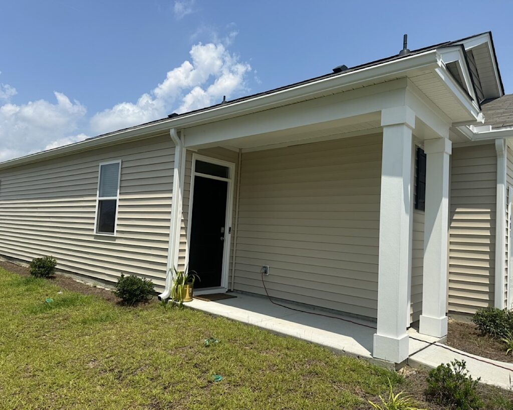 Long run of seamless gutters installed flat to the fascia board over front porch in Cane Bay