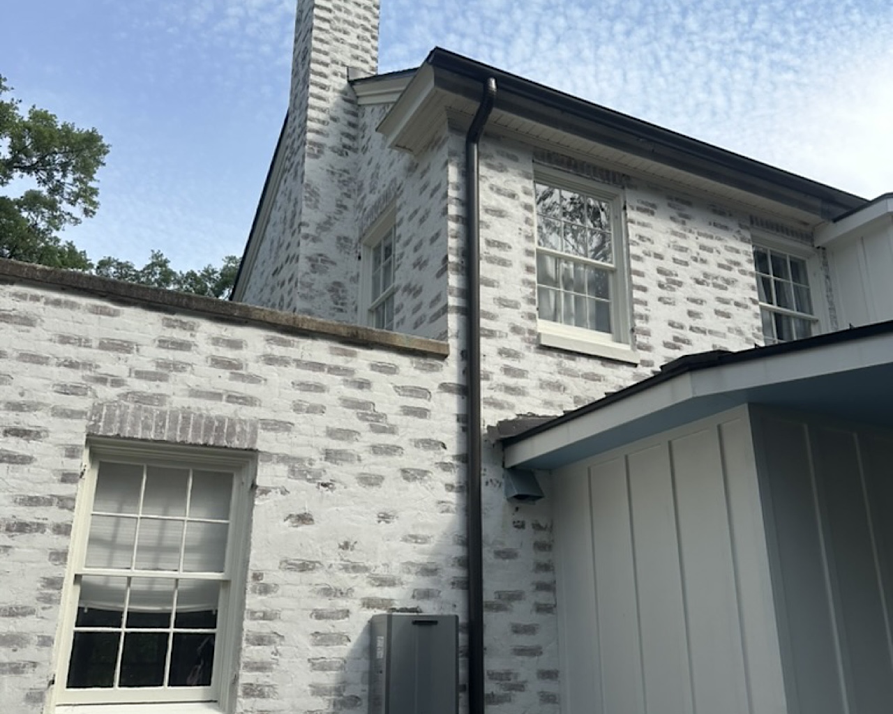 Dark bronze half round gutters and 4" round downspouts installed on brick home in West Ashley SC